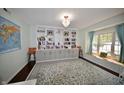 Bright living room with custom built-in shelving, a large rug, and a cozy window seat at 13509 Dunes Dr, Carmel, IN 46032