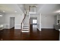 Bright open-concept living room with wood floors and staircase at 13509 Dunes Dr, Carmel, IN 46032