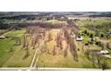 Aerial view of a large grassy property dotted with mature trees and showcasing a scenic pond at 15123 E 196Th St, Noblesville, IN 46060