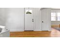 A white door with a glass pane leads to an entryway with hardwood floors at 1521 Kessler Blvd E Dr, Indianapolis, IN 46220