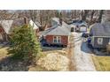Aerial view of a brick home with a well-manicured lawn and detached garage at 1521 Kessler Blvd E Dr, Indianapolis, IN 46220