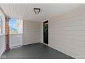 View of a covered porch with a stained concrete floor and a wooden door with a wreath at 1521 Kessler Blvd E Dr, Indianapolis, IN 46220