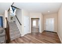 Inviting entryway with wood flooring, a staircase, and a view into the adjacent room at 16406 Taconite Dr, Noblesville, IN 46060