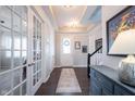 Elegant foyer with dark hardwood floors, tray ceilings, and a view of the staircase and glass-paneled office doors at 1671 Avondale Dr, Westfield, IN 46074