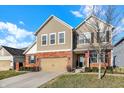 Inviting two-story home featuring a brick facade, siding, attached garage, and well-maintained landscaping at 16736 Workington Way, Westfield, IN 46074