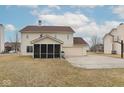 Spacious backyard featuring a screened-in porch, a well-maintained lawn, and an attached two-car garage at 17953 Forreston Oak Dr, Noblesville, IN 46062