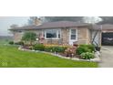 Landscaped front yard with stone accents, garden beds, and quaint seating area at 204 W Pullman St, Waldron, IN 46182