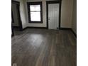 Neutral living room with freshly installed gray, wide-plank laminate flooring and white walls at 238 S Temple Ave, Indianapolis, IN 46201