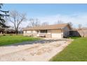 View of the ranch-style home showcasing the attached garage and long driveway, offering ample parking at 348 W Stop 11 Rd, Indianapolis, IN 46217