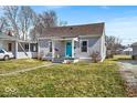 Quaint home featuring a bright blue front door and a well-maintained lawn at 4529 Norwaldo Ave, Indianapolis, IN 46205