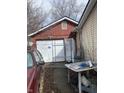 Garage with a white door and a red painted exterior, including a peek at a red car at 4718 W 36Th St, Indianapolis, IN 46222