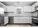 Bright kitchen boasts white cabinets, granite countertops, and stainless steel appliances at 5118 E 69Th St, Indianapolis, IN 46220
