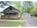 Beautiful home with blue siding, front porch, a detached garage, and lush greenery at 5603 S Randolph St, Indianapolis, IN 46227