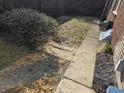 A compact backyard with a sidewalk along the house and a partially shaded grassy area at 5915 Winthrop Ave, Indianapolis, IN 46220