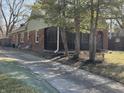 Cozy home featuring a brick exterior, screened-in porch, and a long driveway at 5915 Winthrop Ave, Indianapolis, IN 46220