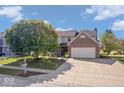 Two-story home featuring a brick facade, two-car garage, landscaped front yard and mature trees at 63 Presidential Way, Brownsburg, IN 46112
