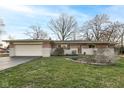 Charming brick ranch home with attached garage, and well-manicured lawn at 6914 Honnen W Dr, Indianapolis, IN 46256
