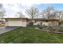 Charming brick ranch home with attached garage, and well-manicured lawn at 6914 Honnen W Dr, Indianapolis, IN 46256