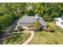 Aerial view of a home with lush green surroundings, complemented by a curved walkway and mature landscaping at 6980 N Pennsylvania St, Indianapolis, IN 46220