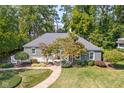Well-maintained front yard featuring lush greenery and mature trees, complemented by a charming walkway at 6980 N Pennsylvania St, Indianapolis, IN 46220