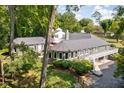 The backyard of the home has lush greenery, a brick patio area, and stairs leading to a deck at 6980 N Pennsylvania St, Indianapolis, IN 46220