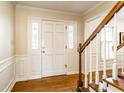 Inviting foyer features hardwood floors, a staircase with wood railing, and a view into other living spaces at 804 Bennett Ct, Carmel, IN 46032