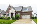 Beautiful brick home with stone accents, lush lawn, and a spacious three-car garage and driveway at 12167 Ams Run, Carmel, IN 46032