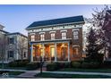 Inviting brick home featuring a covered front porch with seating, elegant architectural details, and manicured landscaping at 13018 Deerstyne Green St, Carmel, IN 46032