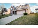 Charming two-story home boasting a brick and siding exterior, complemented by an extended driveway and green lawn at 1618 Lavender Ln, Greenwood, IN 46143