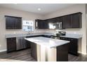 Modern kitchen featuring dark cabinets, granite countertops, stainless steel appliances, and a functional center island at 1618 Lavender Ln, Greenwood, IN 46143