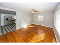 Open living room with hardwood floors and a ceiling fan, connected to an updated kitchen at 310 Sundown Mnr, Mooresville, IN 46158