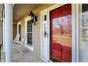 Inviting front porch with seating, a red door, and a charming lantern at 5785 Susan E Dr, Indianapolis, IN 46250
