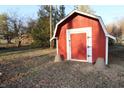 Quaint red outbuilding with a white door, adding charm to the property at 710 Hanna St, Plainfield, IN 46168