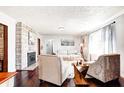 Bright living room features a stone fireplace, comfortable seating and lots of natural light at 7816 E St Joseph St, Indianapolis, IN 46219