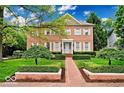 Stately brick home featuring crisp white shutters and meticulously maintained landscaping at 8015 Heyward Dr, Indianapolis, IN 46250
