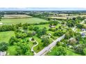 Expansive aerial view of a lush, green property with mature trees and winding paths at 905 S Maple St, Fortville, IN 46040