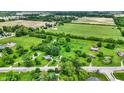 Aerial view featuring a sprawling green property with farm land at 905 S Maple St, Fortville, IN 46040