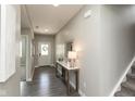 Inviting entryway with gray walls, wood floors, stylish console table, and a view of the front door with a wreath at 9709 Tampico Chase, Fishers, IN 46040