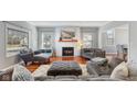 Cozy living room with a brick fireplace, plush seating, and beautiful hardwood floors at 10145 Northwind Dr, Indianapolis, IN 46256
