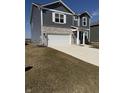 Two story home boasts vinyl siding, stone accents, two car garage, and a long concrete driveway at 10950 N Heirloom Dr, Monrovia, IN 46157
