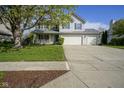 Two-story home with a covered porch, a three-car garage and a well-maintained lawn at 11458 Falling Water Way, Fishers, IN 46037