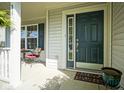 Cozy front porch featuring an elegant dark front door and a sitting area with a small table at 11458 Falling Water Way, Fishers, IN 46037