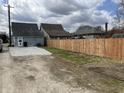 A fenced backyard features a gravel parking area next to a garage at 117 N 10Th St, Elwood, IN 46036