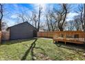 View of the home's backyard with a wooden deck, fenced yard, and gray siding at 1209 N Rural St, Indianapolis, IN 46201