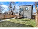 View of the home's backyard with a wooden deck, fenced yard, and gray siding at 1209 N Rural St, Indianapolis, IN 46201