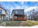 Modern two-story home featuring a front porch with vibrant orange-stained wood and unique architectural design at 1209 N Rural St, Indianapolis, IN 46201