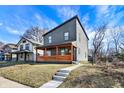 Modern two-story home featuring a front porch with vibrant orange-stained wood and unique architectural design at 1209 N Rural St, Indianapolis, IN 46201