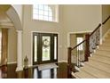 Bright foyer featuring dark wood floors, staircase and a large front door with glass inserts at 1358 Rutherglen Ct, Danville, IN 46122