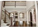 Grand foyer featuring hardwood floors, staircase, and view of living room with fireplace at 1358 Rutherglen Ct, Danville, IN 46122