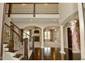 Grand foyer with dark wood floors, staircase, and views into the living room at 1358 Rutherglen Ct, Danville, IN 46122